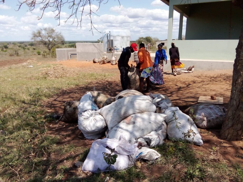 Personas llevando residuos orgánicos a una planta de biogás en Magude.